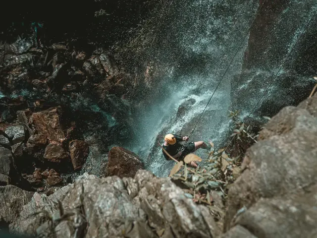 Un descendeur en rappel dans une gorge étroite, vu d'en haut