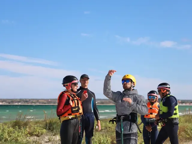 Un groupe en combinaison et casque au bord de l'eau, à la sortie