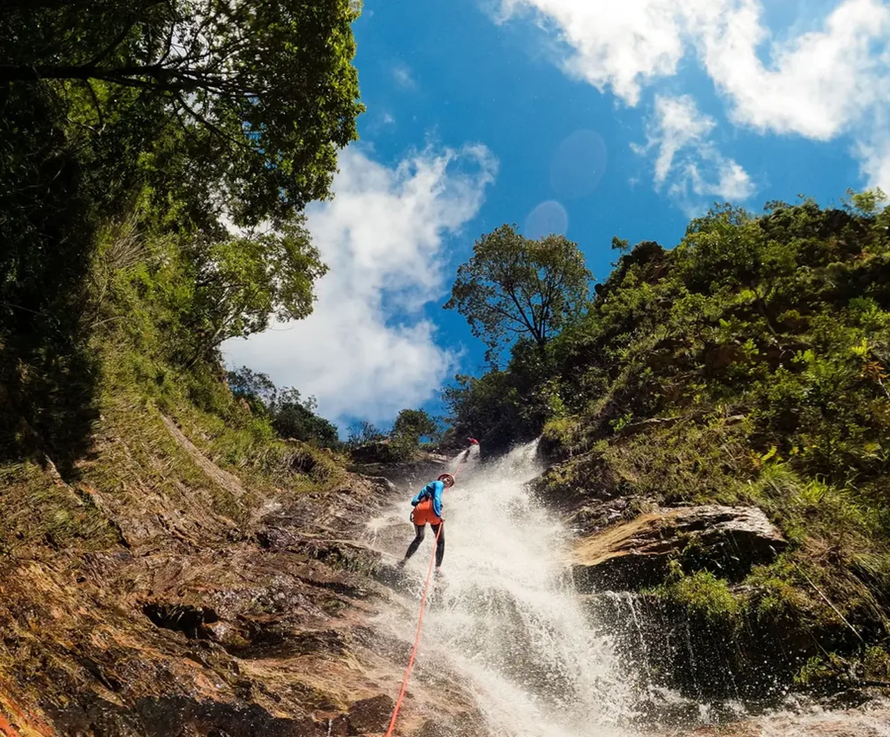 Un participant descend un toboggan naturel dans le canyon