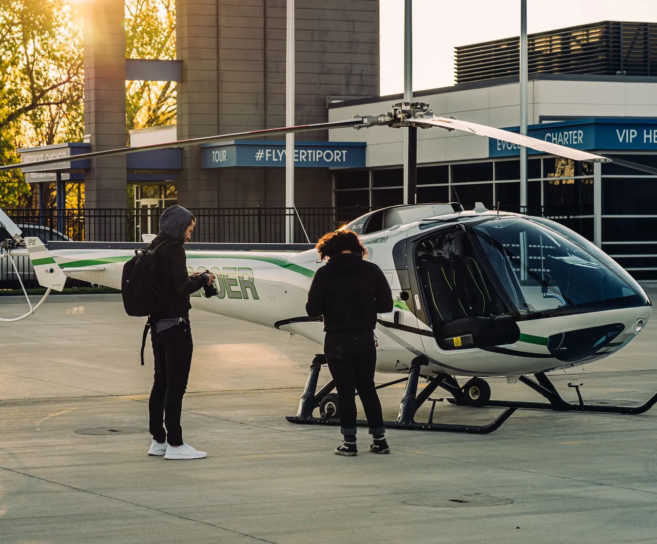 Deux passagers rejoignent l'hélicoptère sur l'aire d'embarquement
