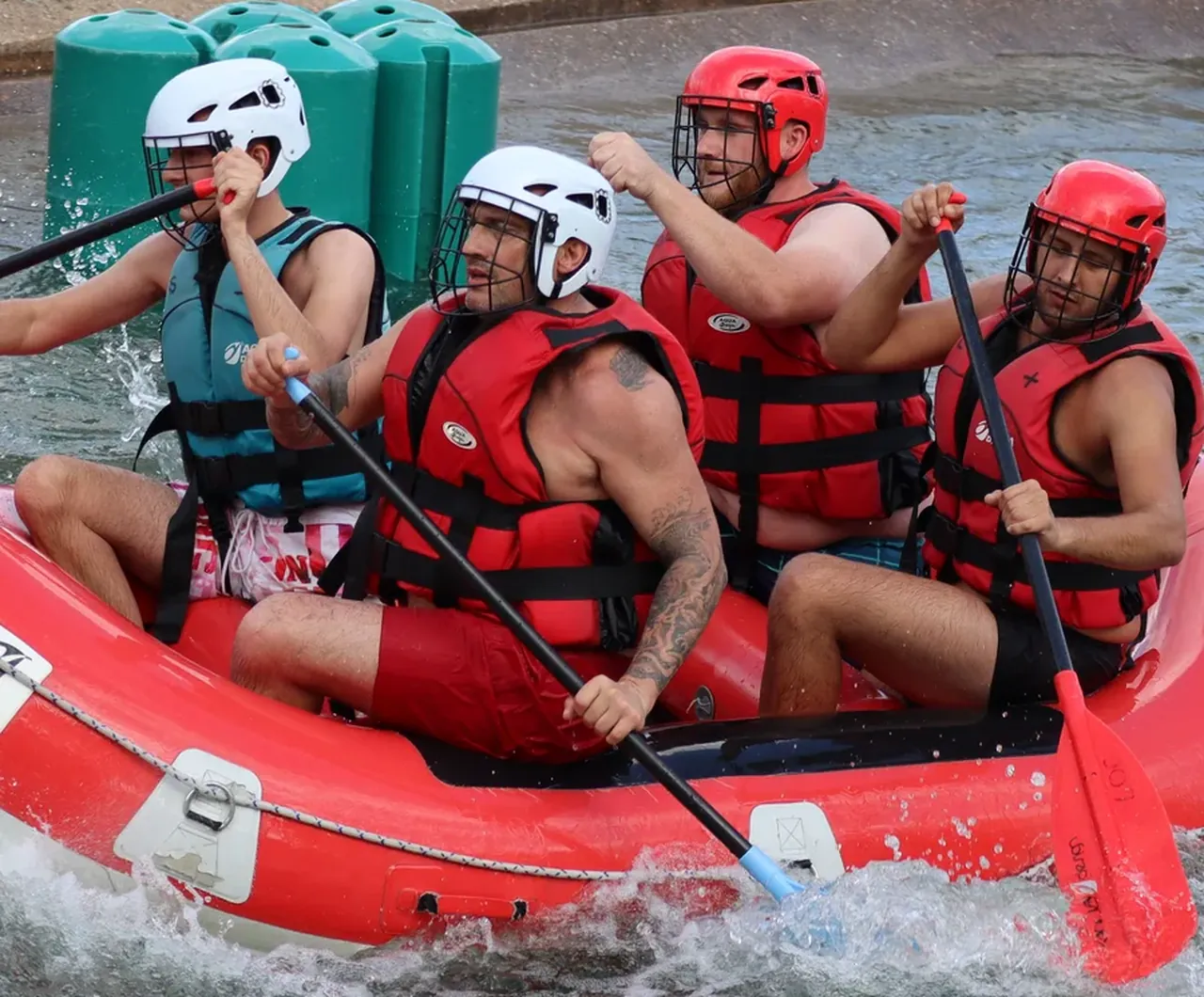 Quatre participants pagayent dans un raft au passage d'un rapide
