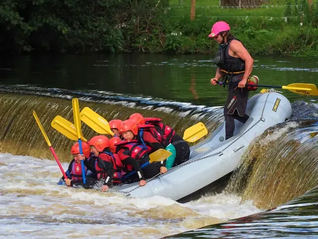 Un raft franchit le seuil, le guide debout à l'arrière