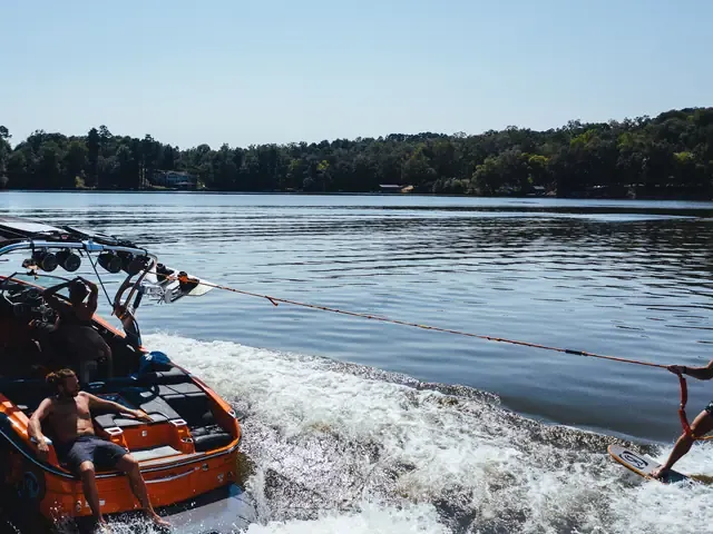 Un bateau tracte un skieur, gerbe d'eau derrière lui